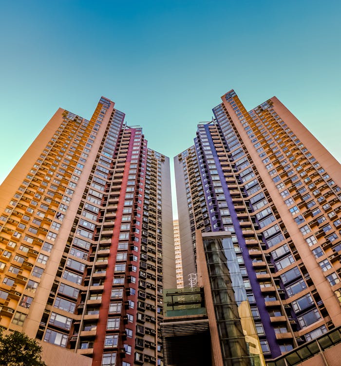 gallery-2 Tall, colorful skyscrapers reaching into the blue sky in Hong Kong, showcasing modern architecture.